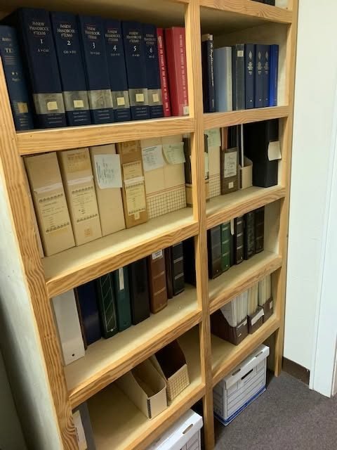 Bound record books and archive boxes on the library shelves